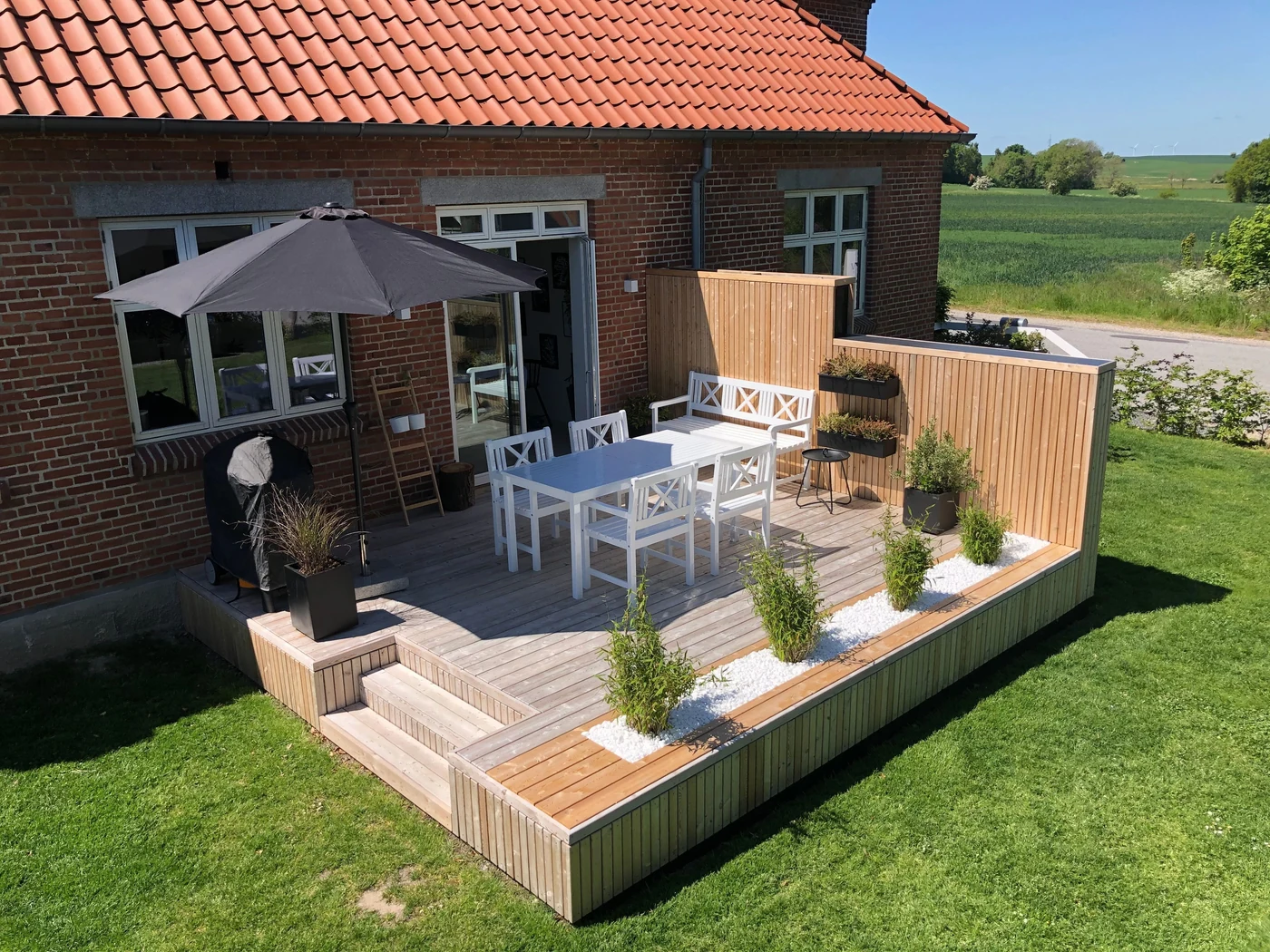 Hævet træterrasse med afskærmning ved haven